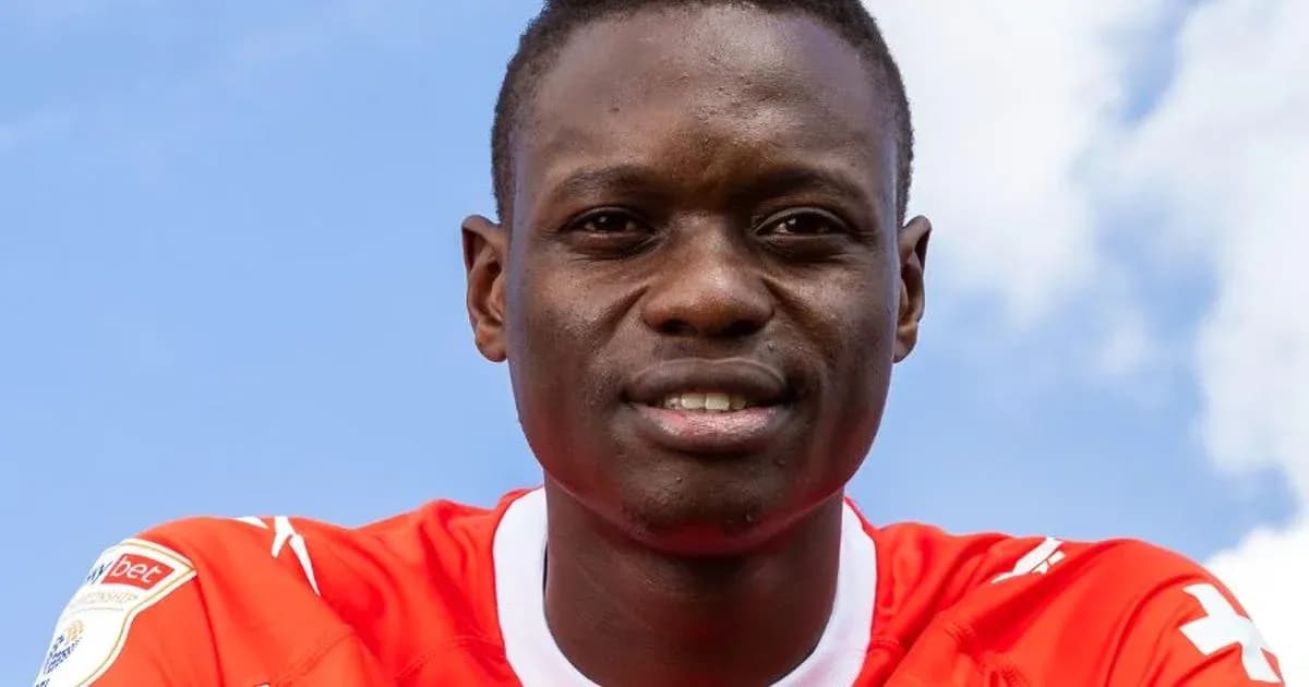 Futbolchi qizil forma kiygan, ko'k osmon fonida Futbolchi qizil forma kiygan, ko'k osmon fonida