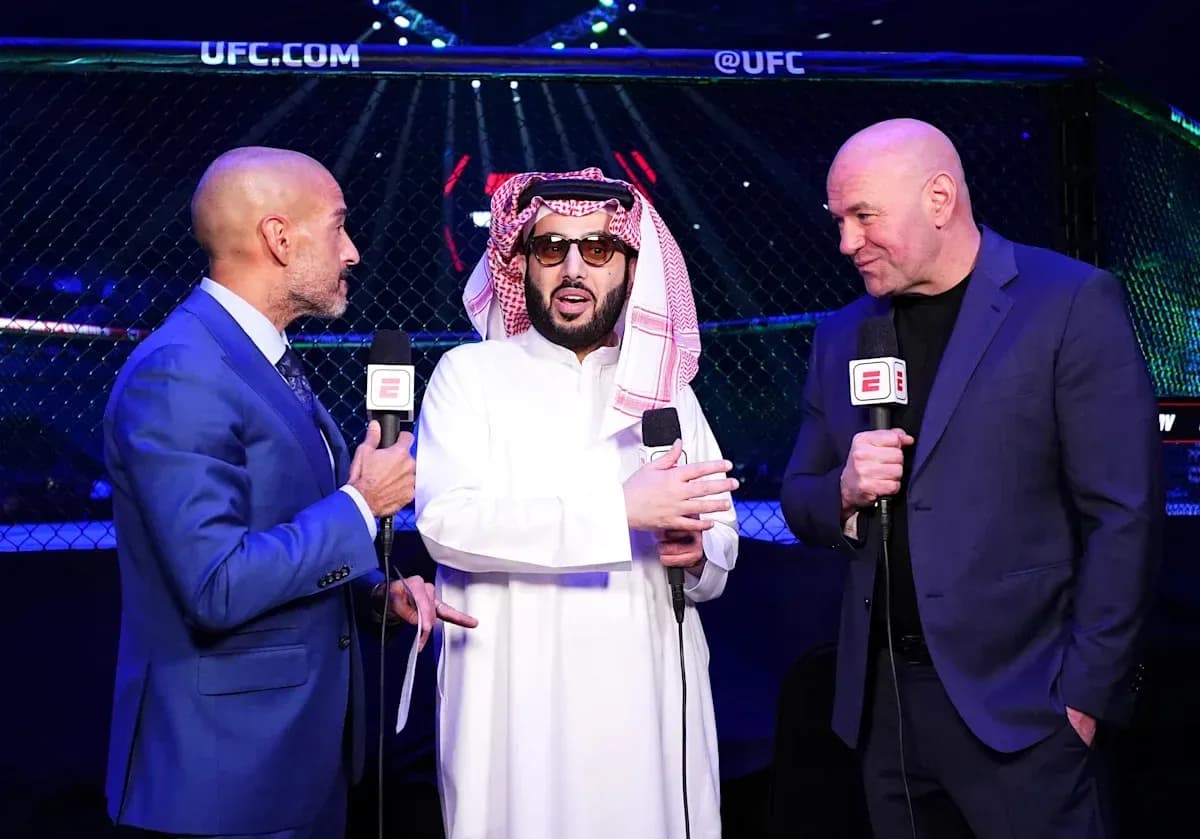 Three men speaking with microphones near UFC octagon Three men speaking with microphones near UFC octagon