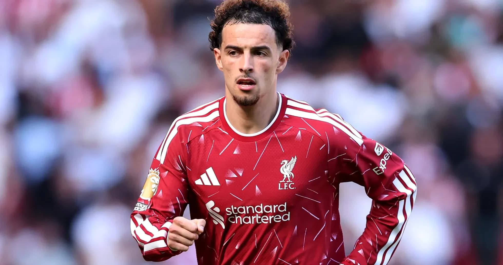 Futbolchi Liverpool formasida maydonda yugurmoqda Futbolchi Liverpool formasida maydonda yugurmoqda