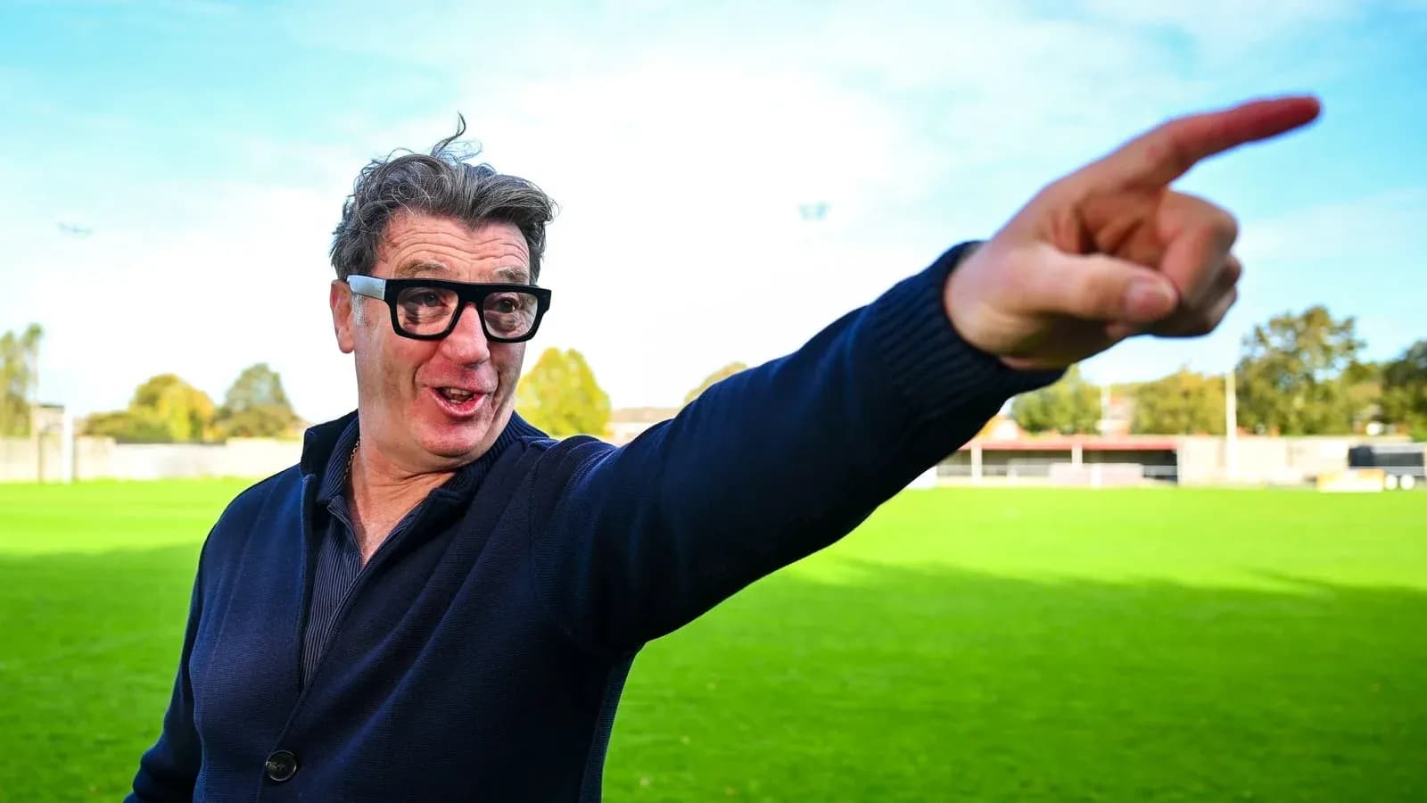 Man pointing on a football field background Man pointing on a football field background