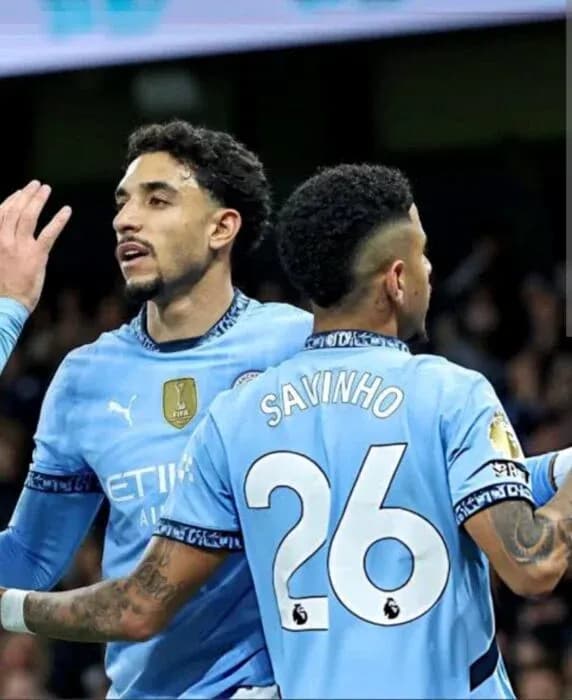 Ikkita futbolchi Manchester City formasida bir-biriga murojaat qilmoqda Ikkita futbolchi Manchester City formasida bir-biriga murojaat qilmoqda