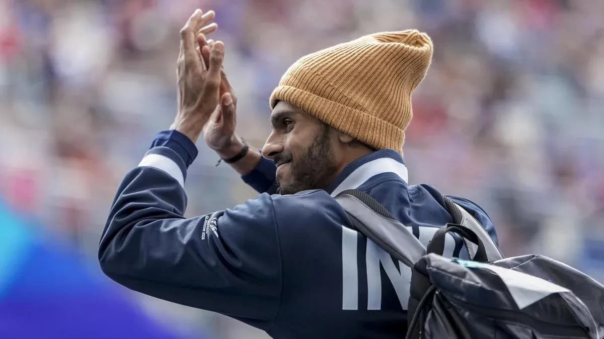 Athlete waving while wearing a beanie and jacket Athlete waving while wearing a beanie and jacket