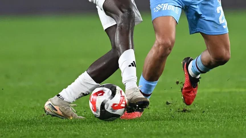 Two players challenging for the ball on field Two players challenging for the ball on field