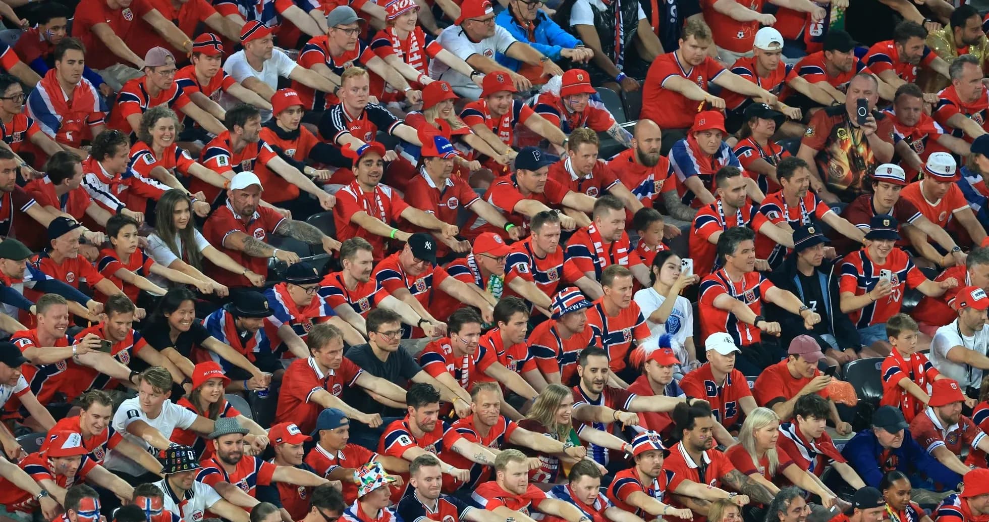 Fans in red jerseys celebrating at stadium Fans in red jerseys celebrating at stadium