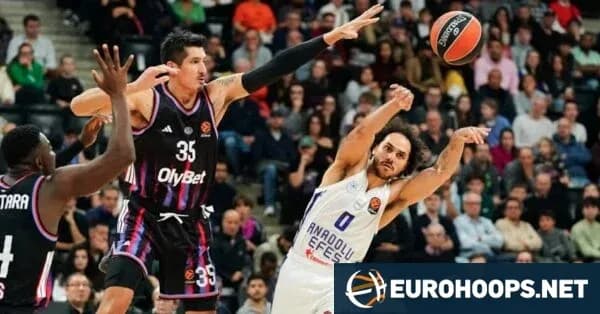 Basketball player shooting while being defended Basketball player shooting while being defended