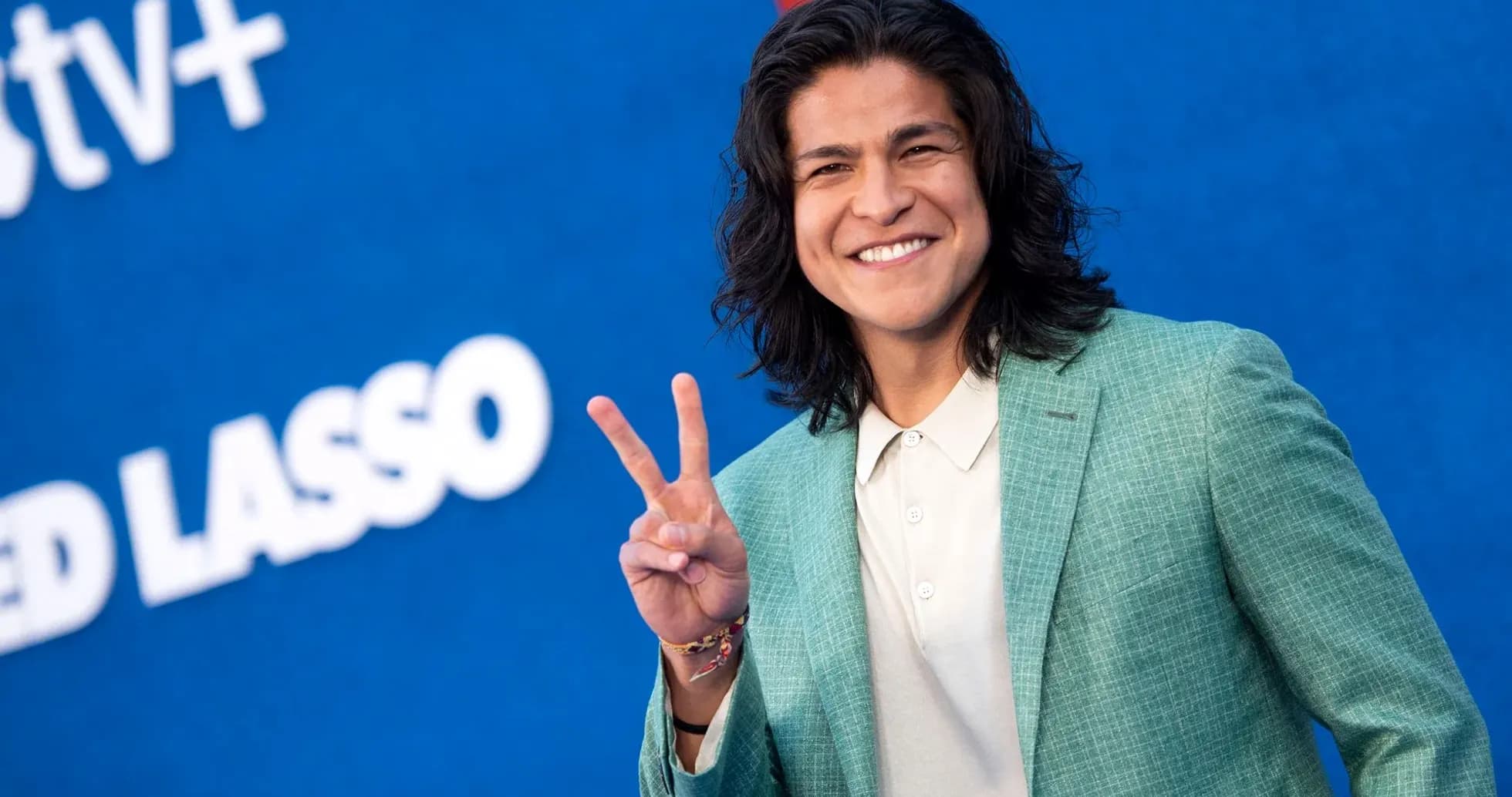 Person smiling and making peace sign at event Person smiling and making peace sign at event