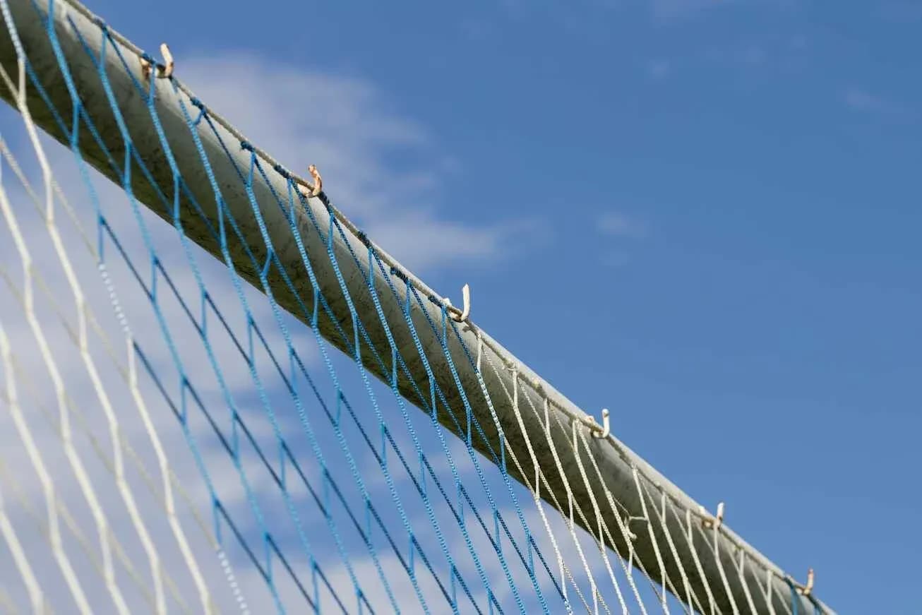 Goal net against a blue sky background Goal net against a blue sky background