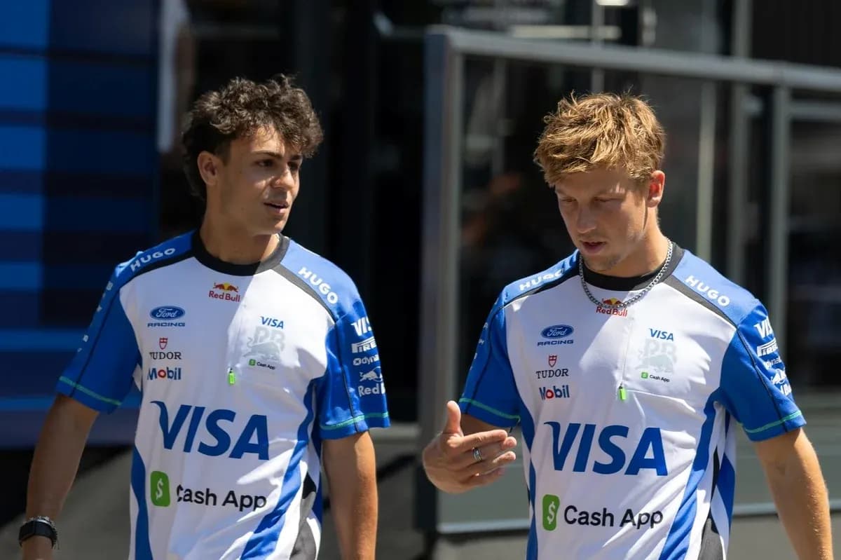Two racing team members discussing in paddock Two racing team members discussing in paddock
