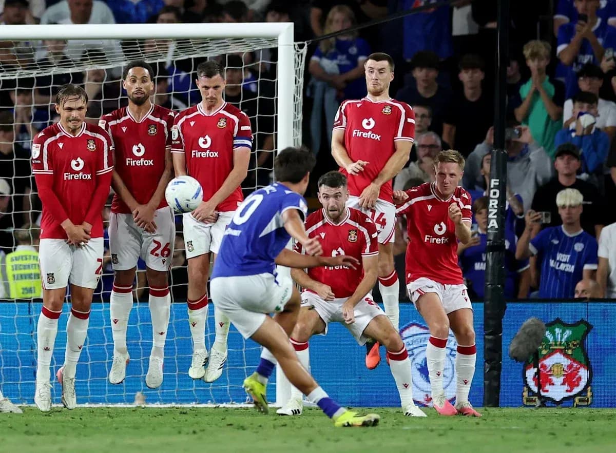 Player taking a free kick with wall defending Player taking a free kick with wall defending