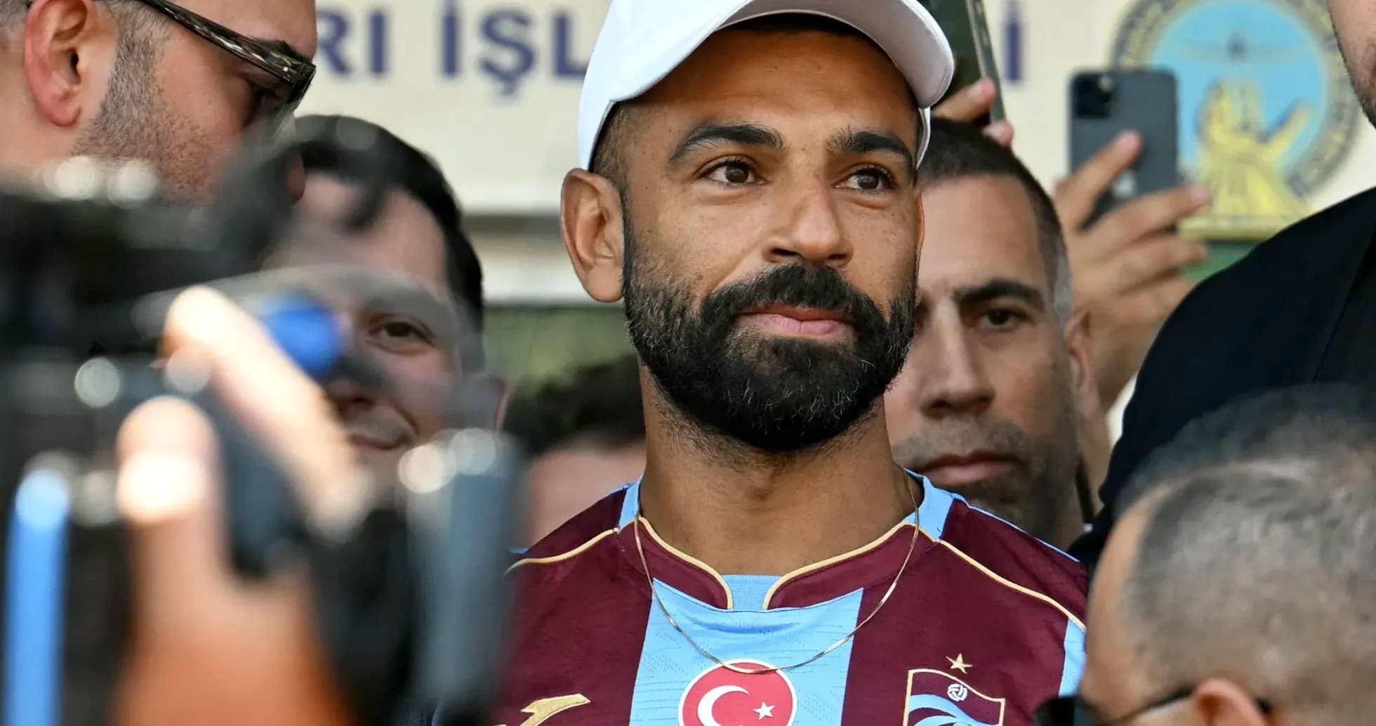 Futbolchi ko'plab muxlislar orasida turibdi Futbolchi ko'plab muxlislar orasida turibdi