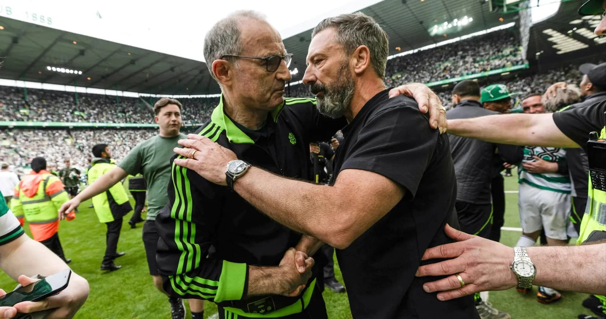 Coaches embracing on the pitch after match Coaches embracing on the pitch after match