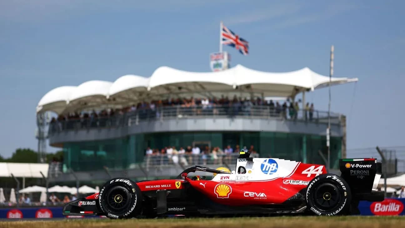 Formula 1 car racing past grandstand at event Formula 1 car racing past grandstand at event