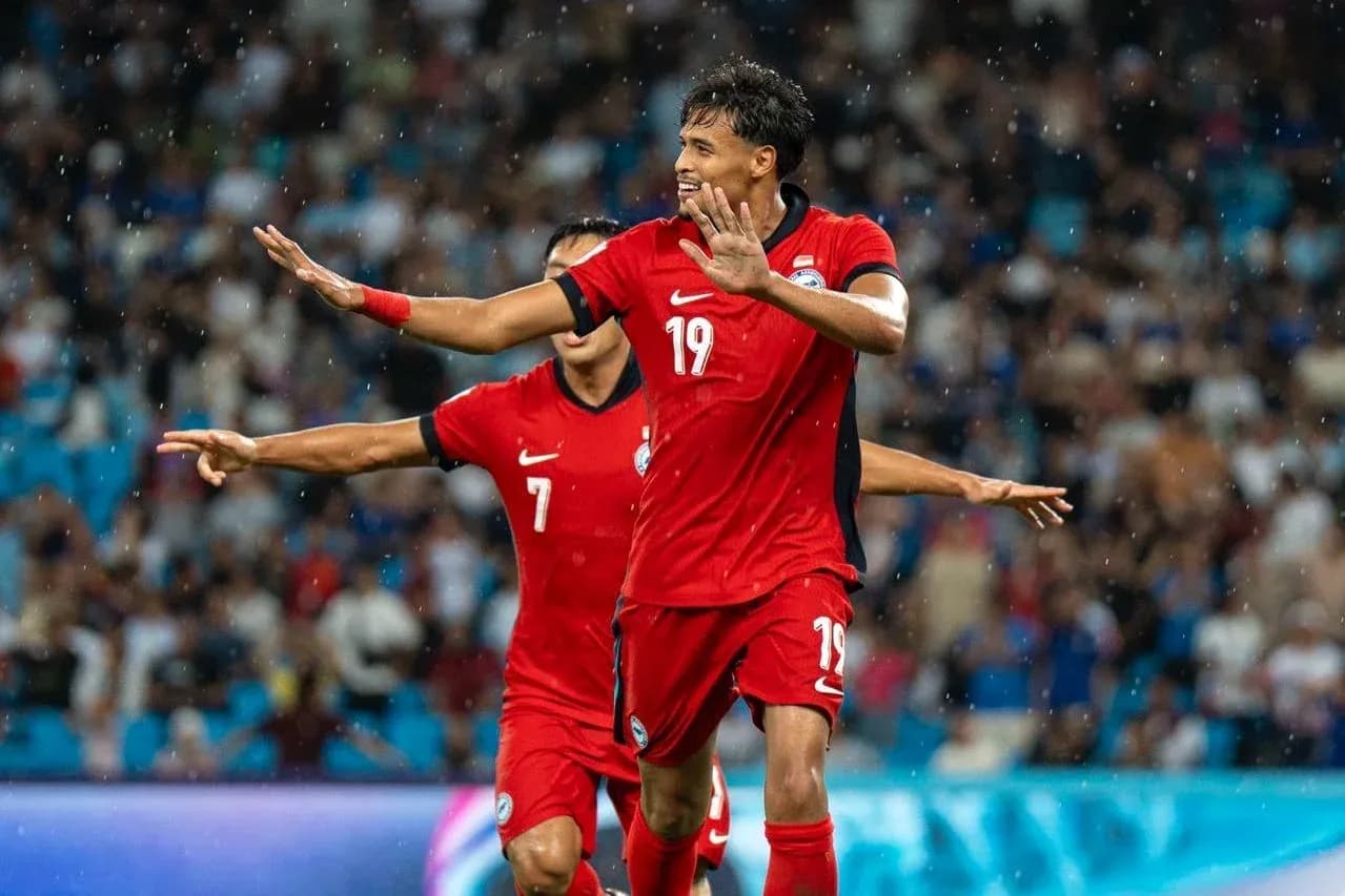 Futbolchi goli uchun nishonlayotgan raqiblar Futbolchi goli uchun nishonlayotgan raqiblar