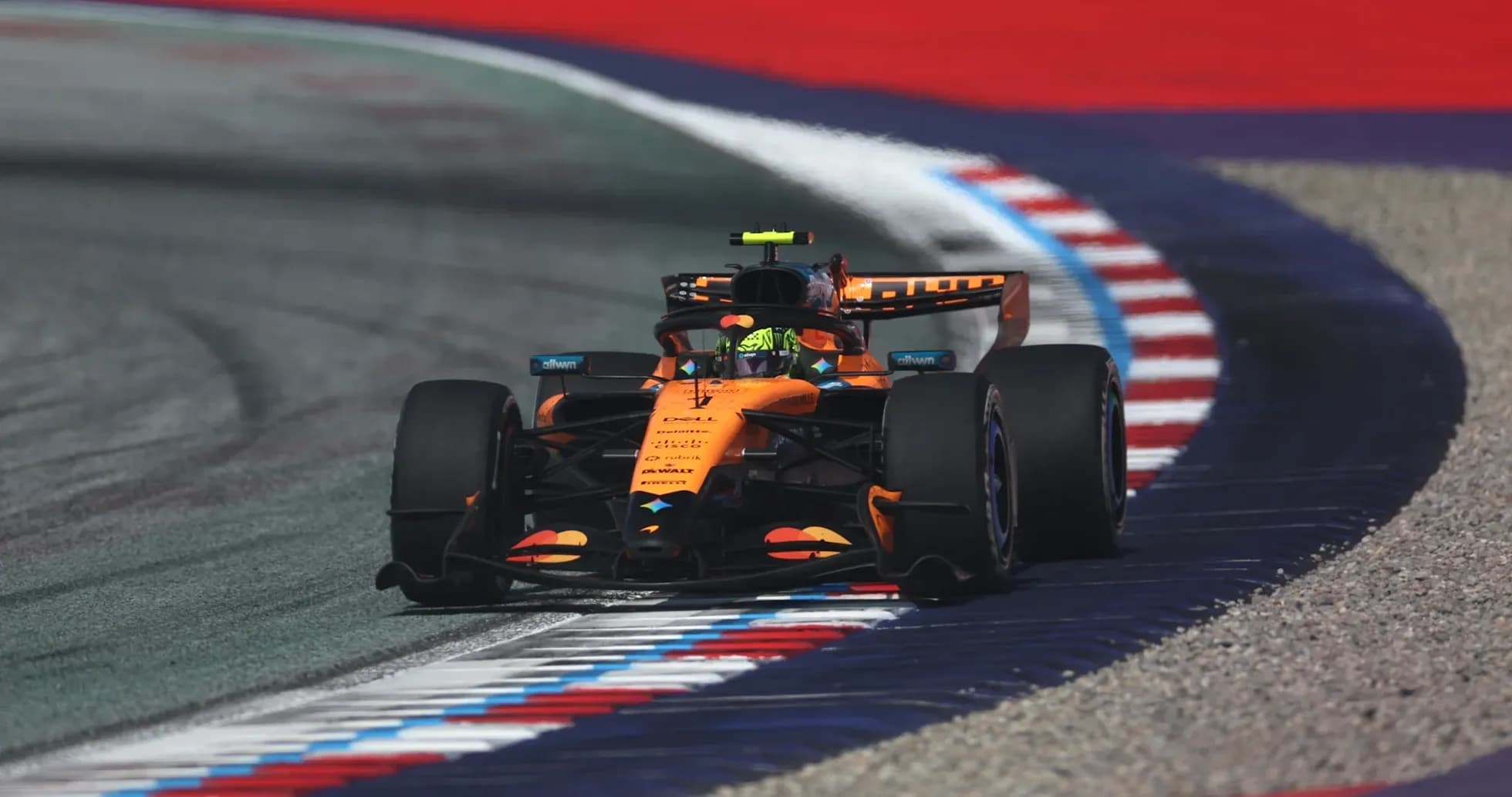 McLaren Formula 1 car navigating a track corner McLaren Formula 1 car navigating a track corner
