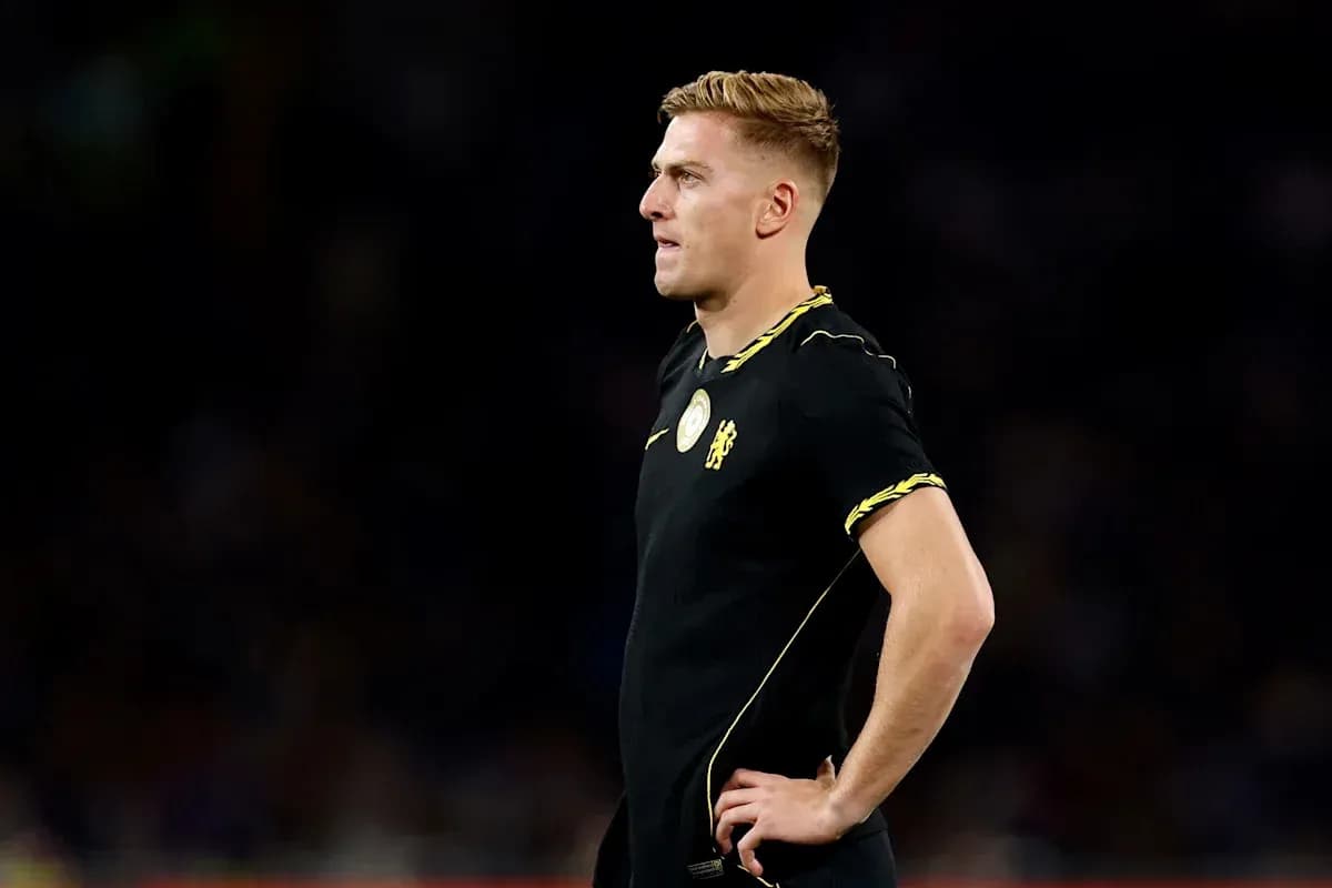 Futbolchi qora formada, maydon bo'yida turibdi Futbolchi qora formada, maydon bo'yida turibdi