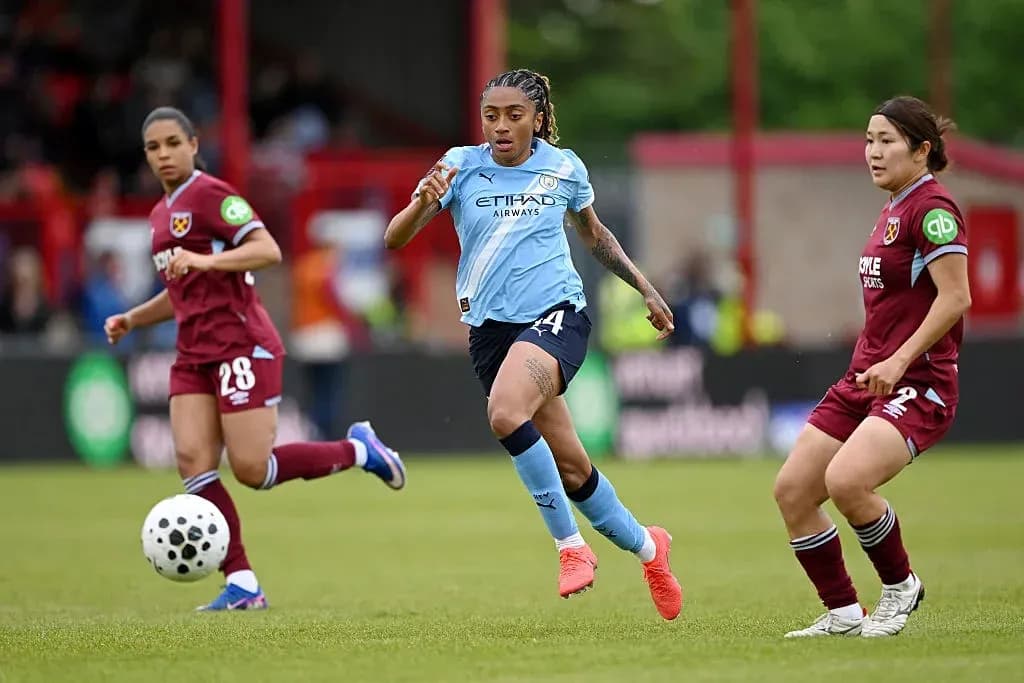 Manchester City player dribbling past West Ham defenders Manchester City player dribbling past West Ham defenders