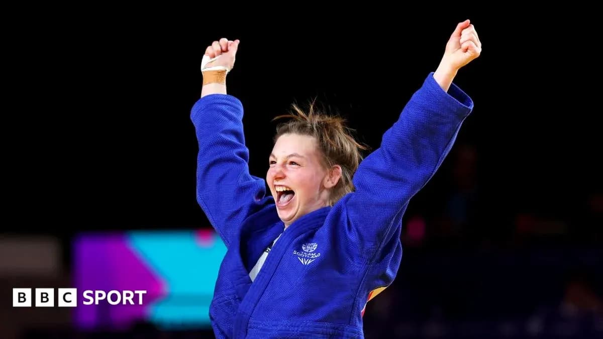 Judo athlete celebrating victory with raised arms Judo athlete celebrating victory with raised arms