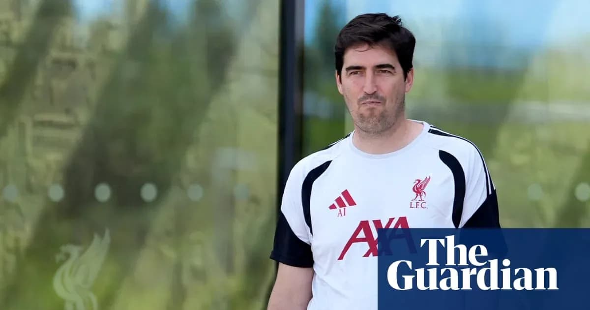 Man in Liverpool training kit walking outside facility Man in Liverpool training kit walking outside facility