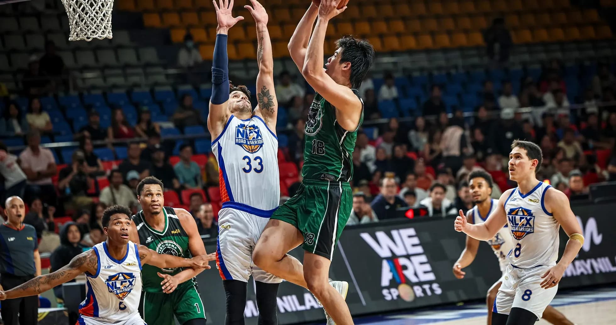 Player shooting basketball while defended by opponent Player shooting basketball while defended by opponent
