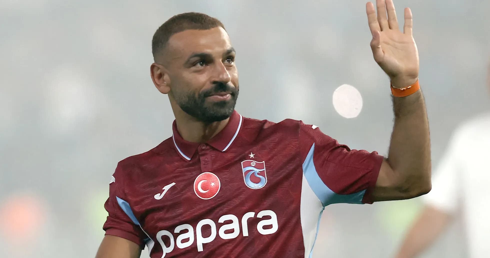 Futbolchi jamoaga qo'shilib, qo'l silkitmoqda Futbolchi jamoaga qo'shilib, qo'l silkitmoqda