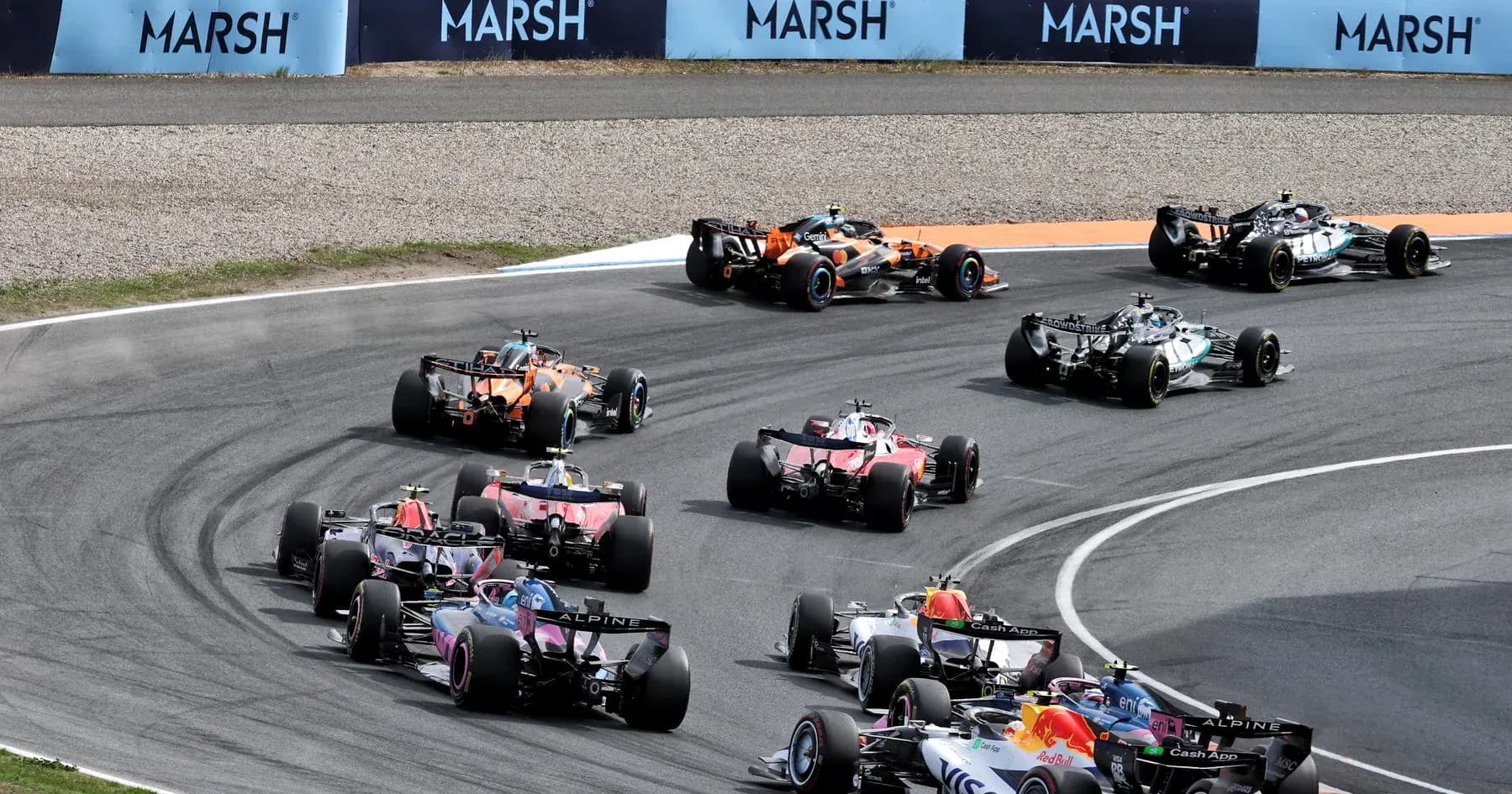 Formula 1 cars racing on a curved track Formula 1 cars racing on a curved track