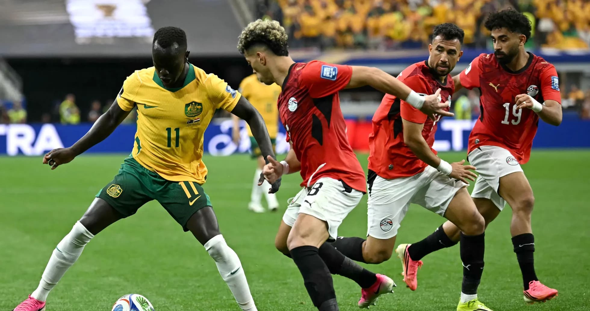 Australia player dribbling past Egyptian defenders in match Australia player dribbling past Egyptian defenders in match