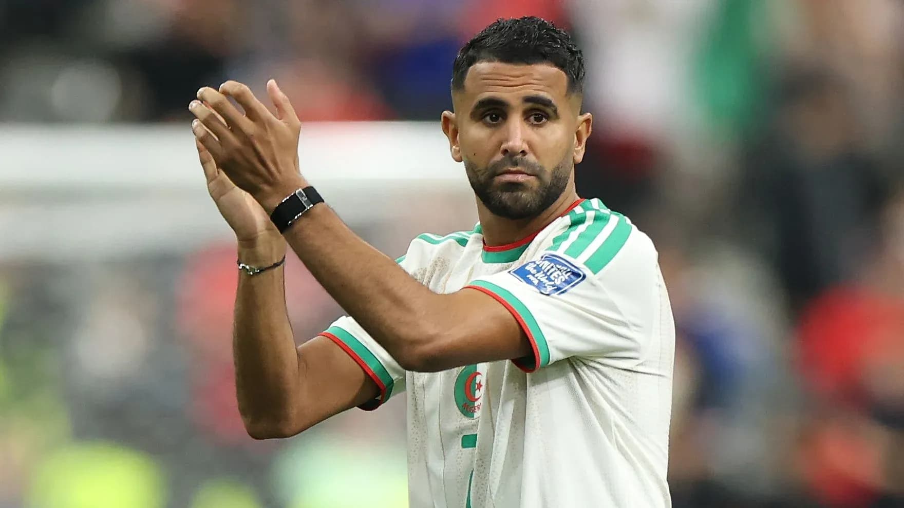 Futbolchi sahna ustida qo'llarini ko'tarib turibdi Futbolchi sahna ustida qo'llarini ko'tarib turibdi