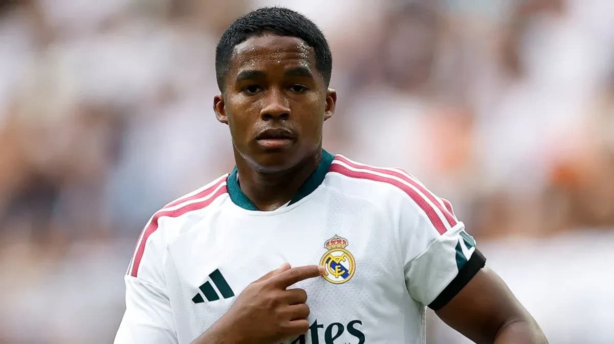 Futbolchi Real Madrid formasida jamoa emblemiga ishora qiladi Futbolchi Real Madrid formasida jamoa emblemiga ishora qiladi