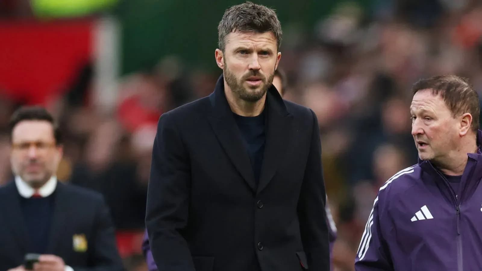 Men in suits walking on the pitch during match Men in suits walking on the pitch during match