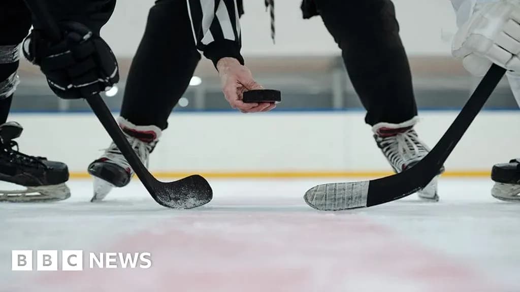 Referee dropping puck for face-off in hockey game Referee dropping puck for face-off in hockey game
