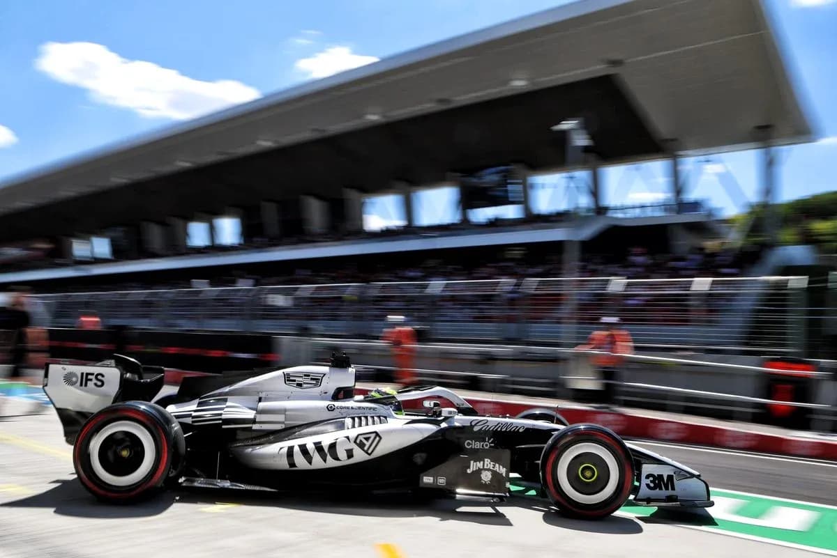Formula 1 car racing past pit building during event Formula 1 car racing past pit building during event