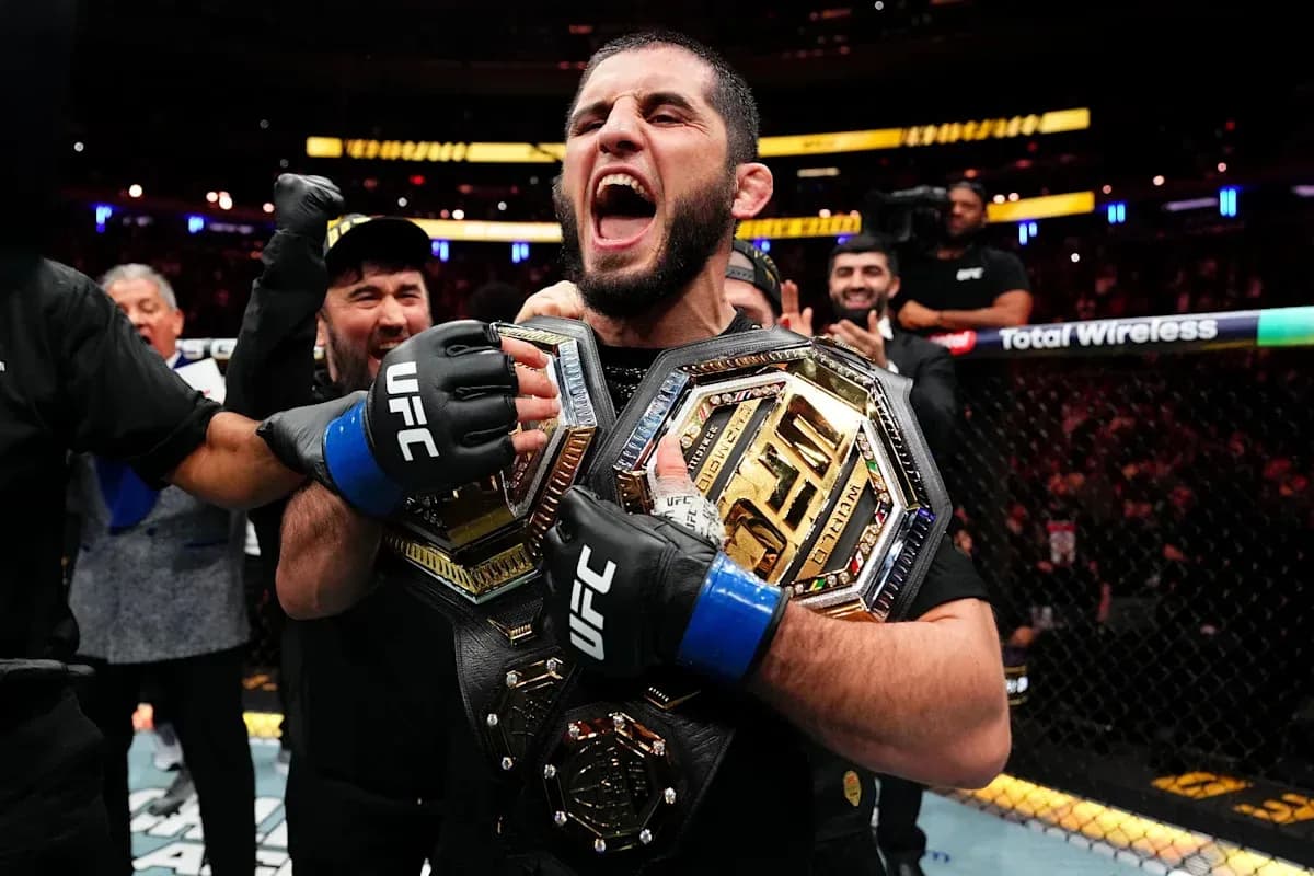 Fighter celebrating with championship belts after victory Fighter celebrating with championship belts after victory
