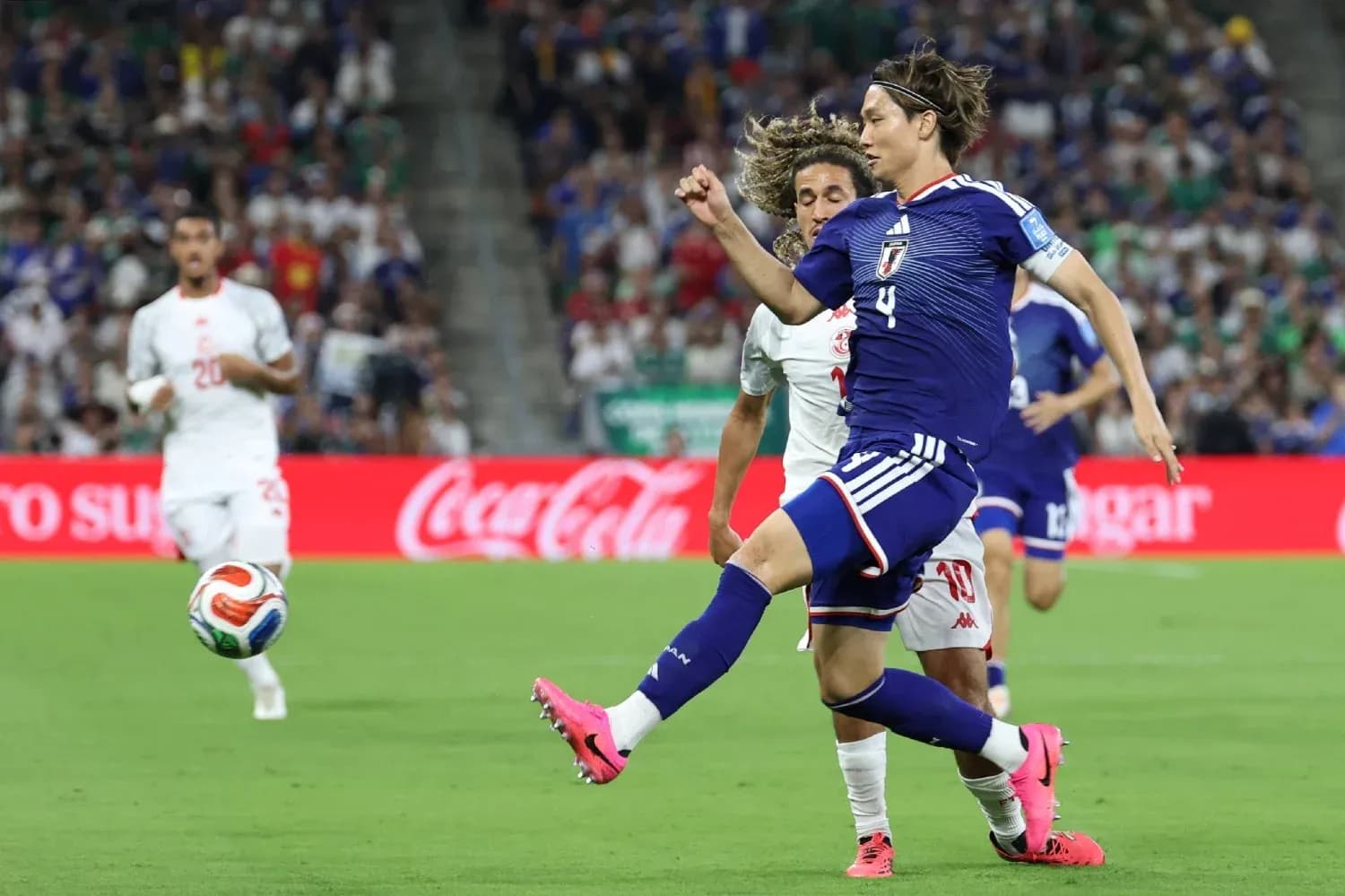 Japan player kicking ball during match against Tunisia Japan player kicking ball during match against Tunisia