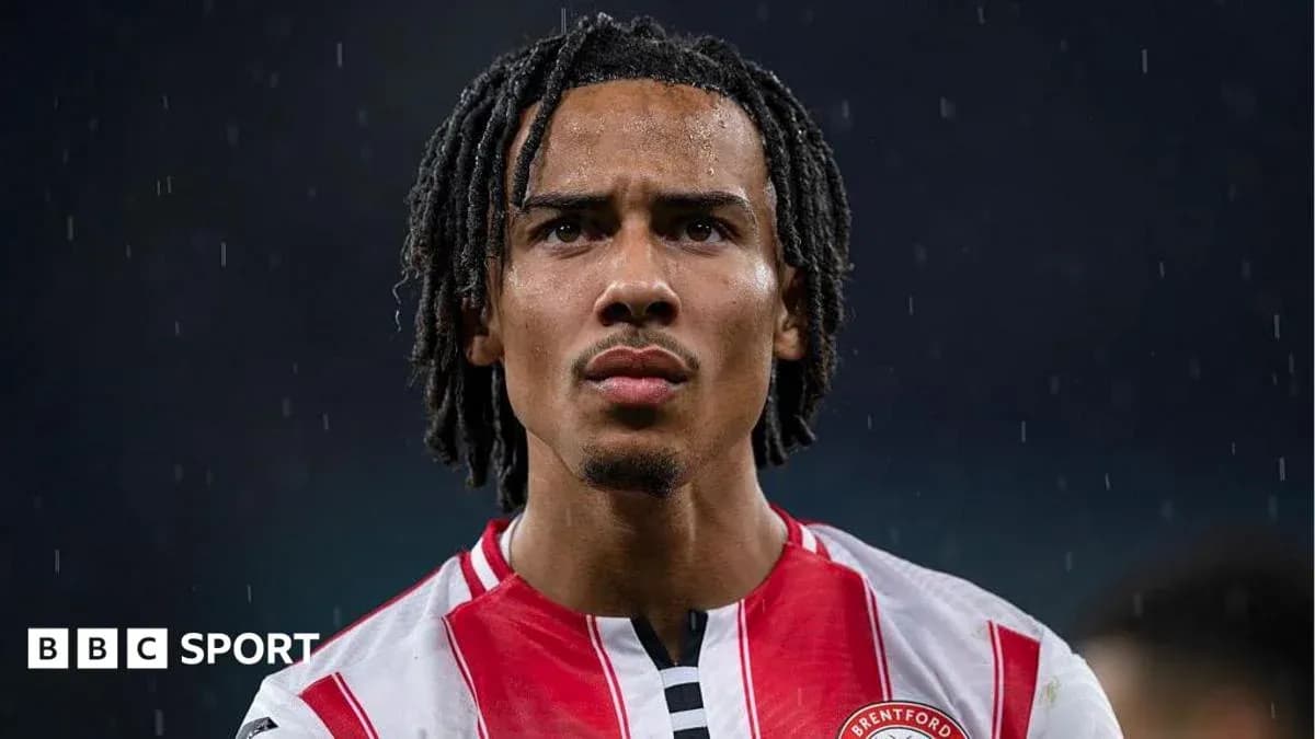 Futbolchi Brentford formasida, yomg'ir ostida turibdi Futbolchi Brentford formasida, yomg'ir ostida turibdi