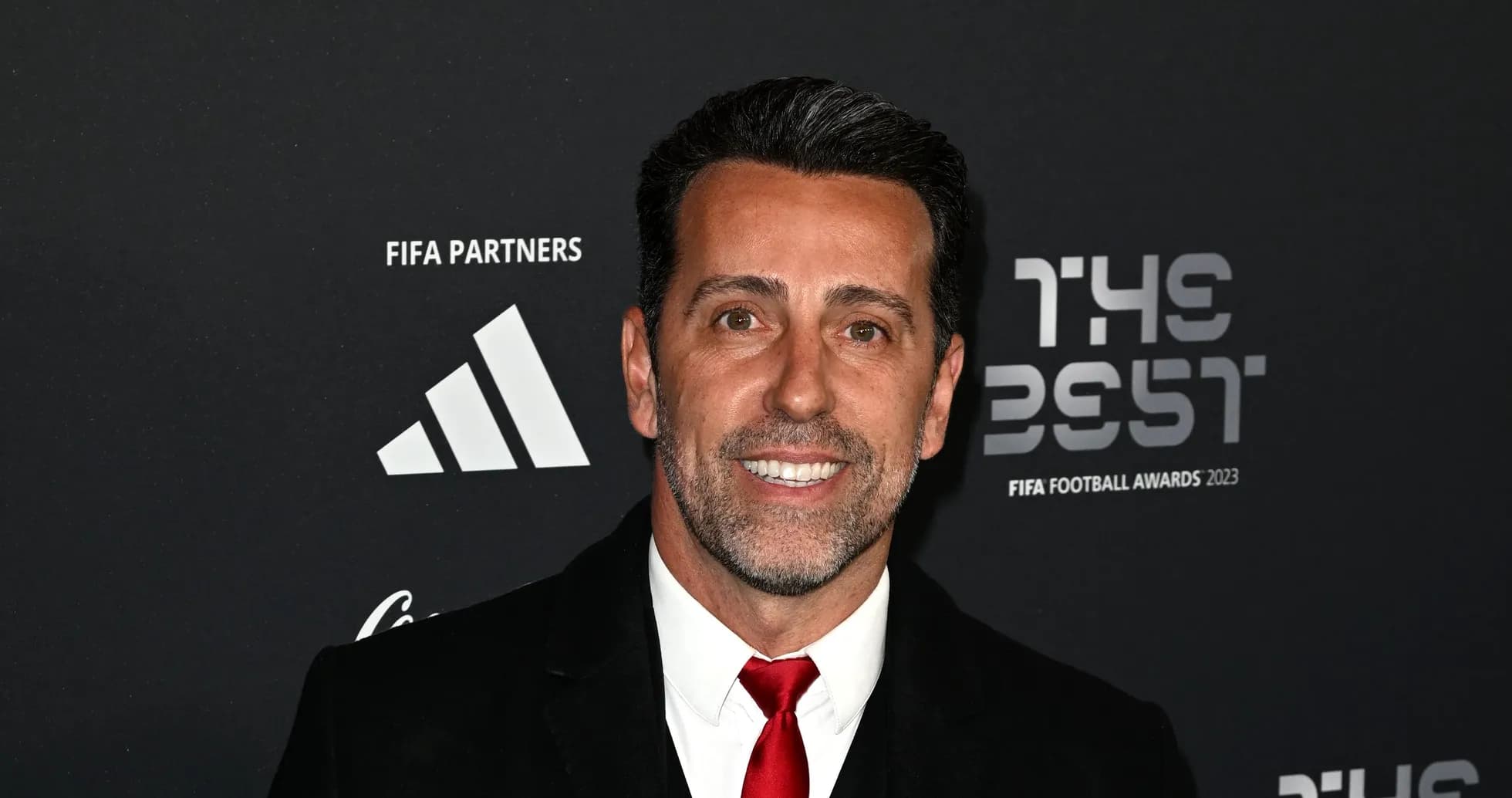 Man smiling at FIFA Football Awards 2023 backdrop Man smiling at FIFA Football Awards 2023 backdrop