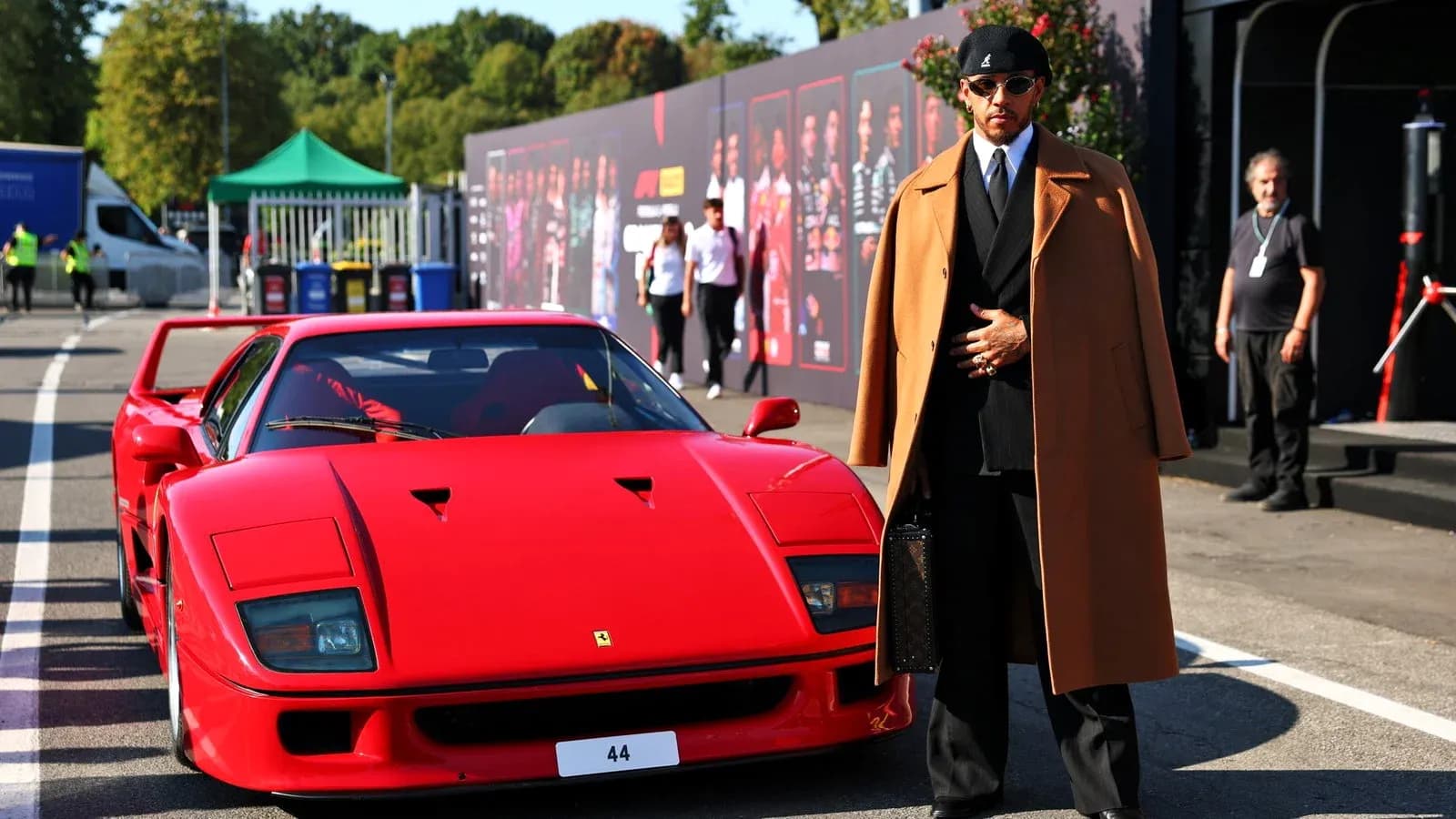 Haydovchi qizil Ferrari oldida turibdi Haydovchi qizil Ferrari oldida turibdi