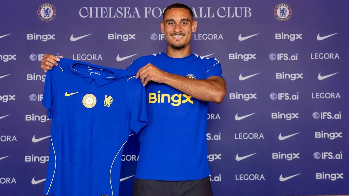 Futbolchi Chelsea futbol formasini ko'rsatmoqda Futbolchi Chelsea futbol formasini ko'rsatmoqda