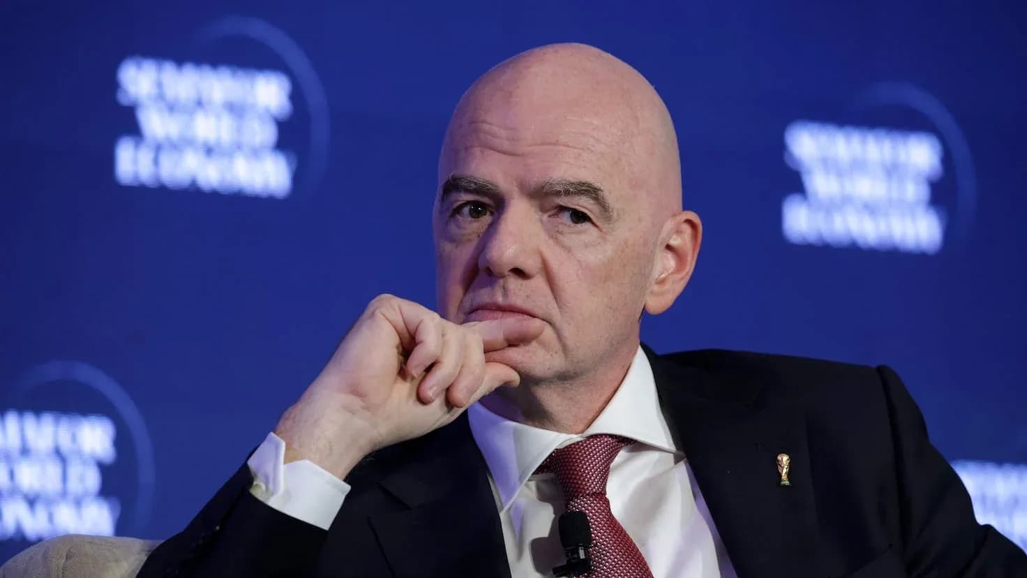 Man speaking at a conference with FIFA emblem Man speaking at a conference with FIFA emblem
