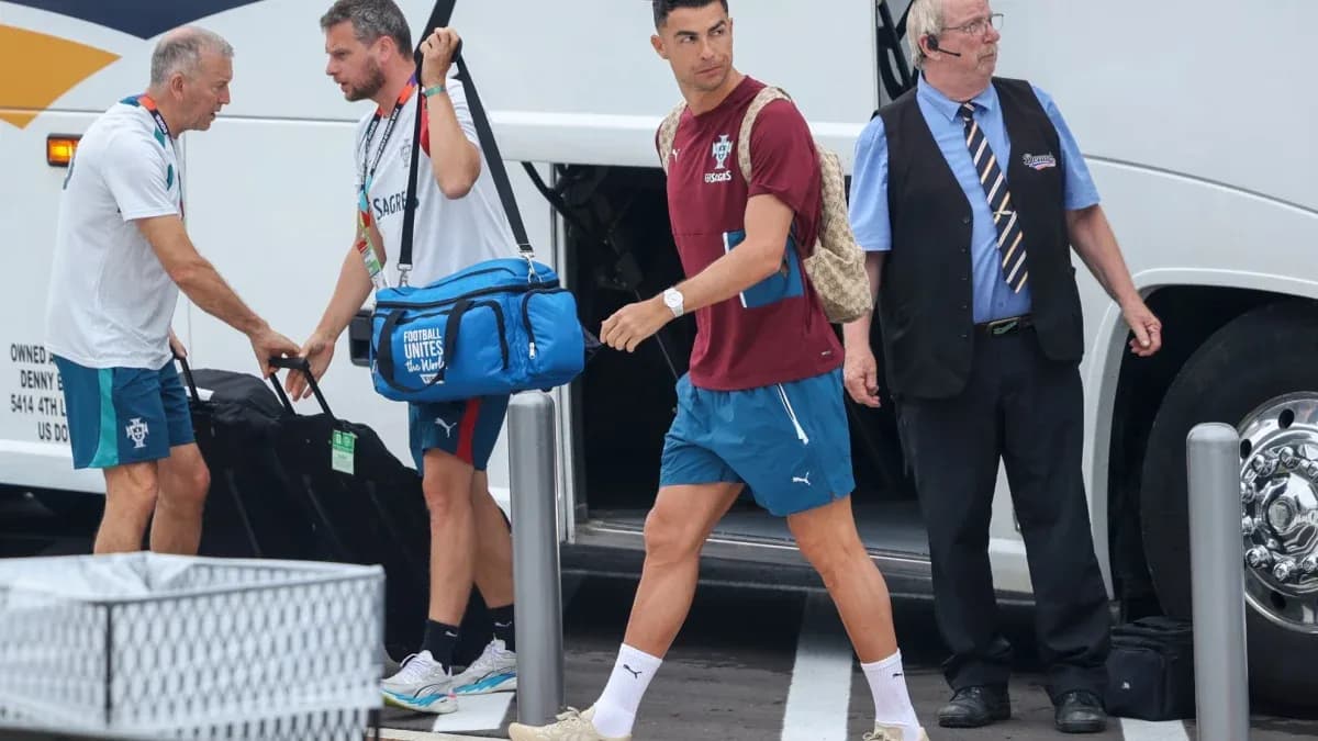 Futbolchilar avtobusdan chiqib, yuklarni ko'tarishmoqda Futbolchilar avtobusdan chiqib, yuklarni ko'tarishmoqda