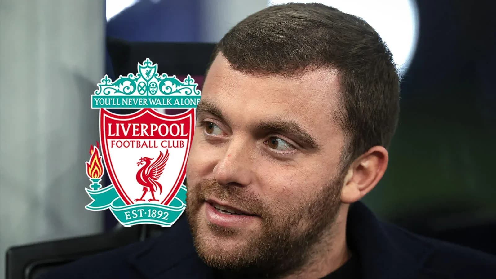 Man speaking with Liverpool FC logo in background Man speaking with Liverpool FC logo in background