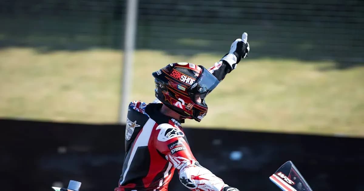 Motocross rider celebrating with raised hand Motocross rider celebrating with raised hand