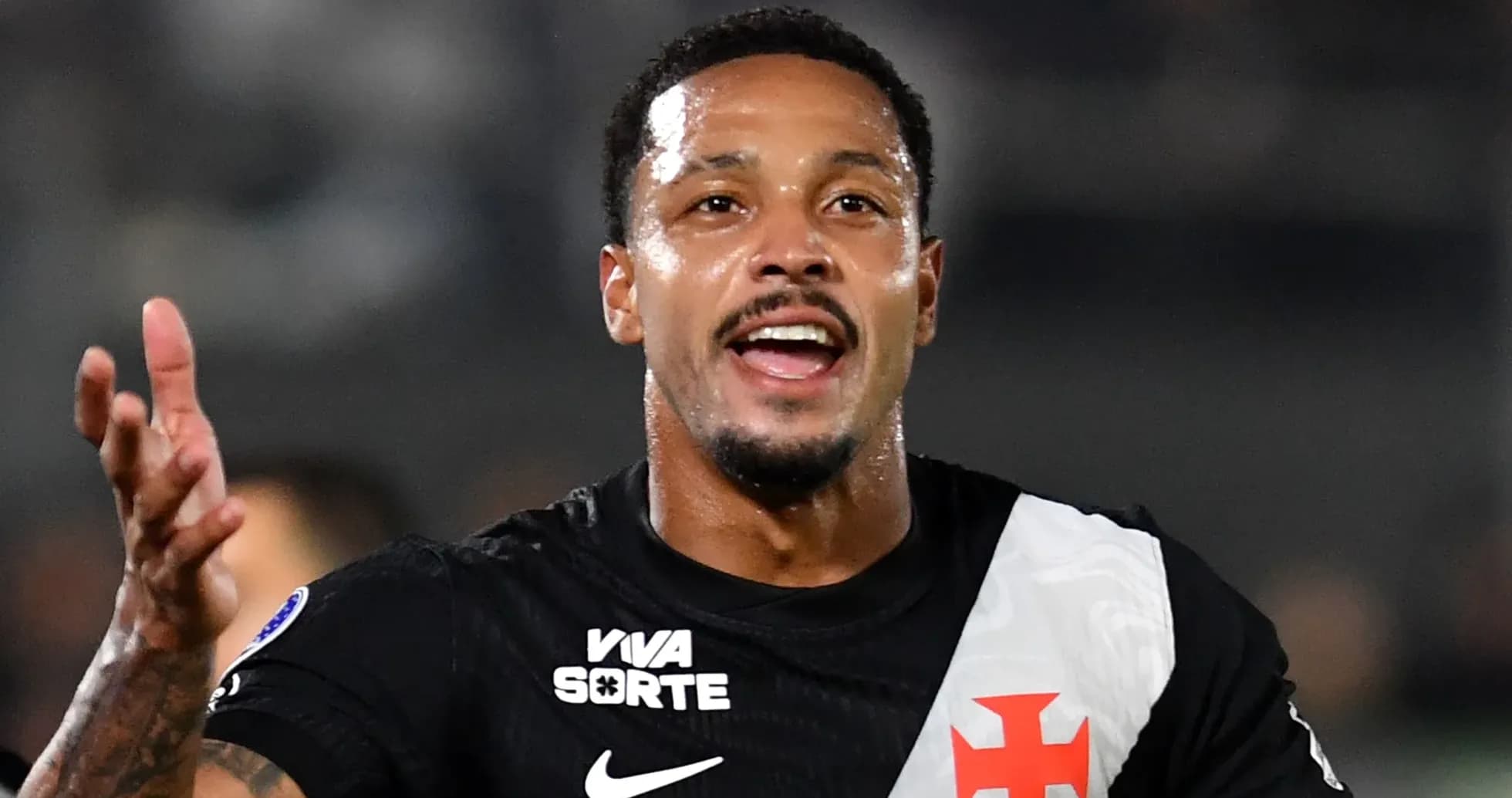 Futbolchi maydonda qo'lini ko'tarib gapiryapti Futbolchi maydonda qo'lini ko'tarib gapiryapti