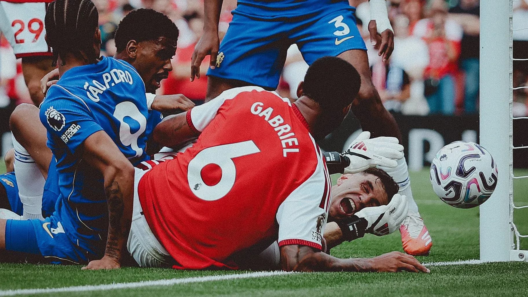 Players contesting near goal during intense match moment Players contesting near goal during intense match moment