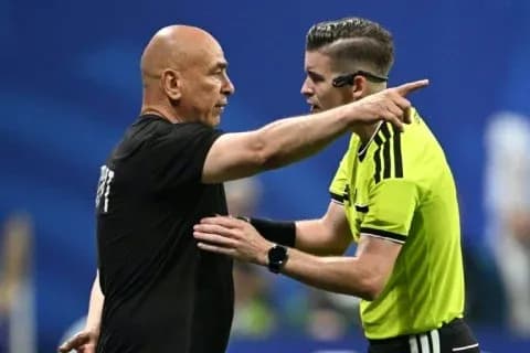 Referee discussing decision with team manager on pitch Referee discussing decision with team manager on pitch
