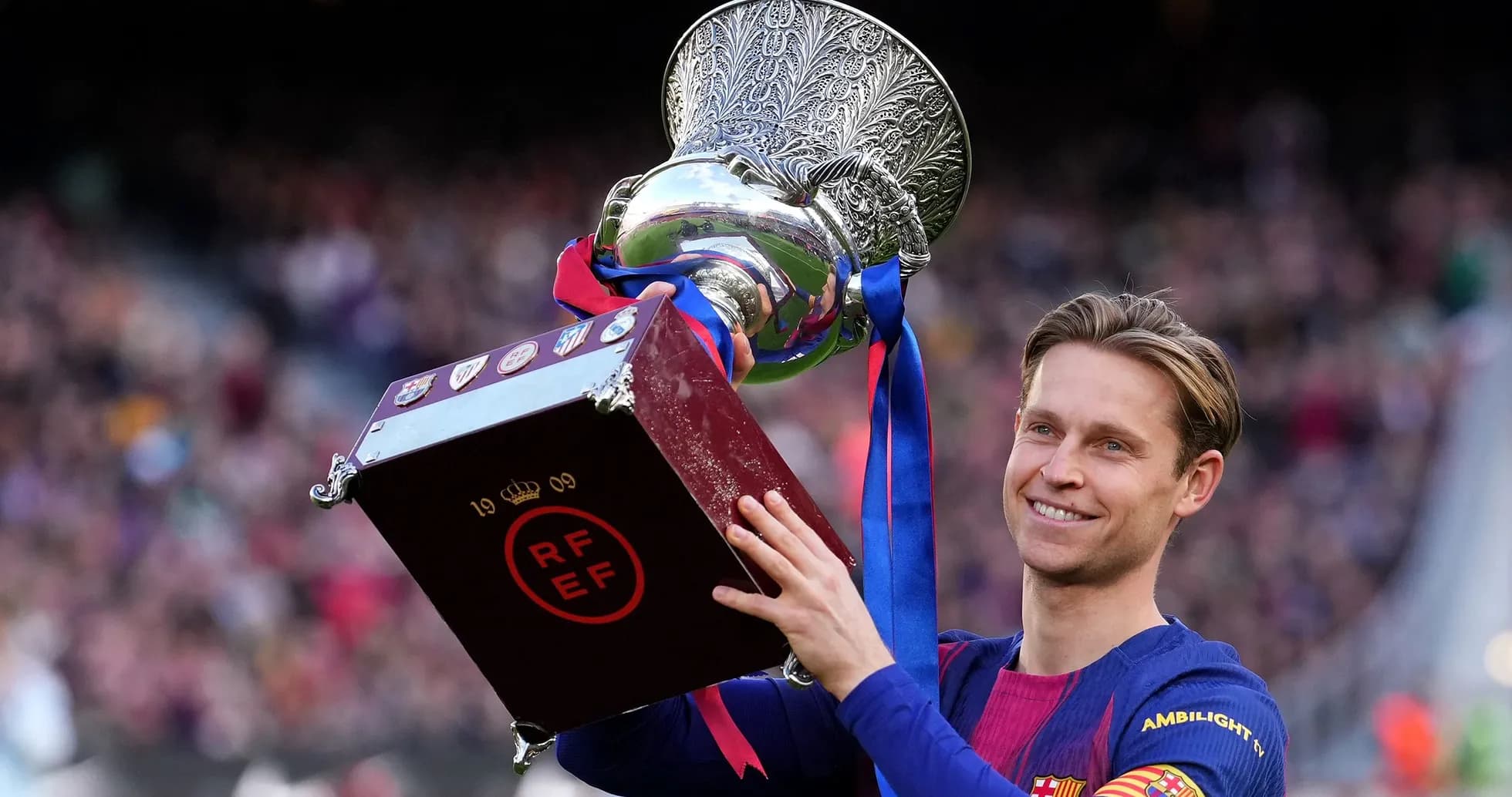 Futbolchi kubokni ko'tarib turib tabriklayapti Futbolchi kubokni ko'tarib turib tabriklayapti