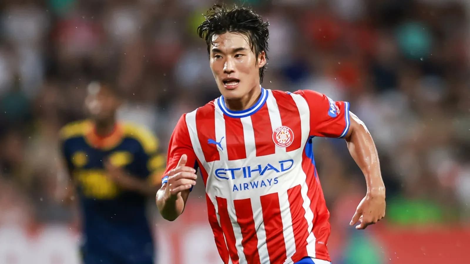 Futbolchi Gernona formasida to'pni quchoqda yugurmoqda Futbolchi Gernona formasida to'pni quchoqda yugurmoqda