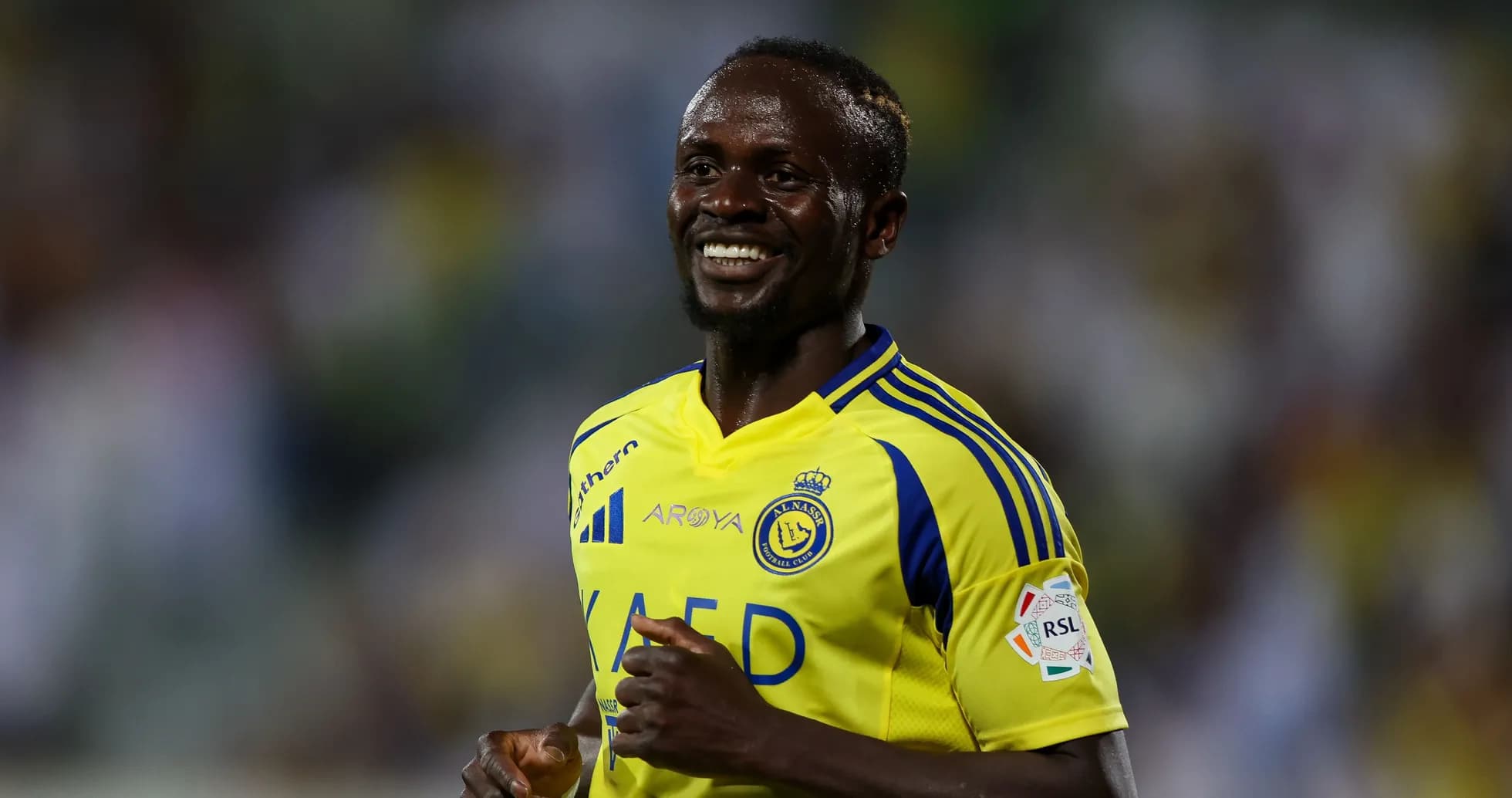Futbolchi maydonda yurgan va tabassum qilayotgan Futbolchi maydonda yurgan va tabassum qilayotgan