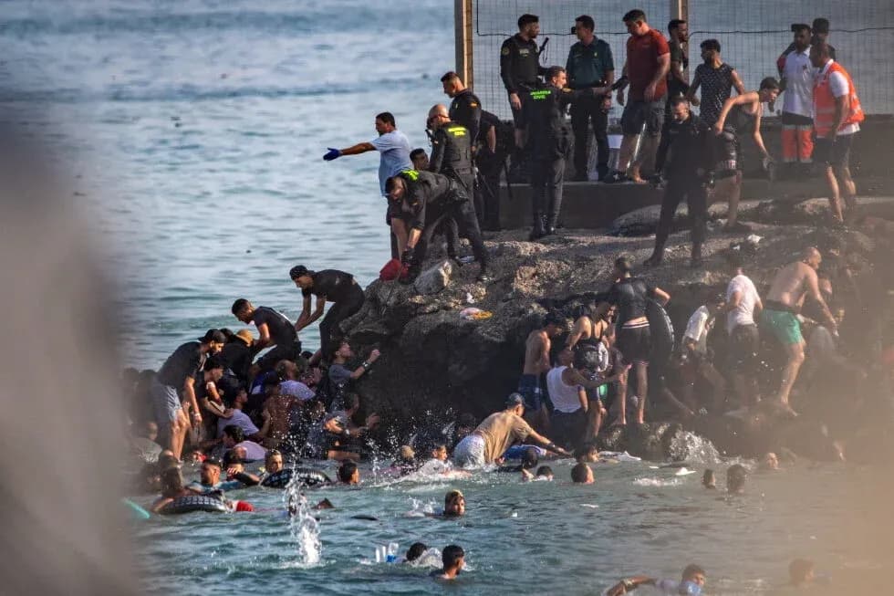 People struggling in water near rocky shore People struggling in water near rocky shore