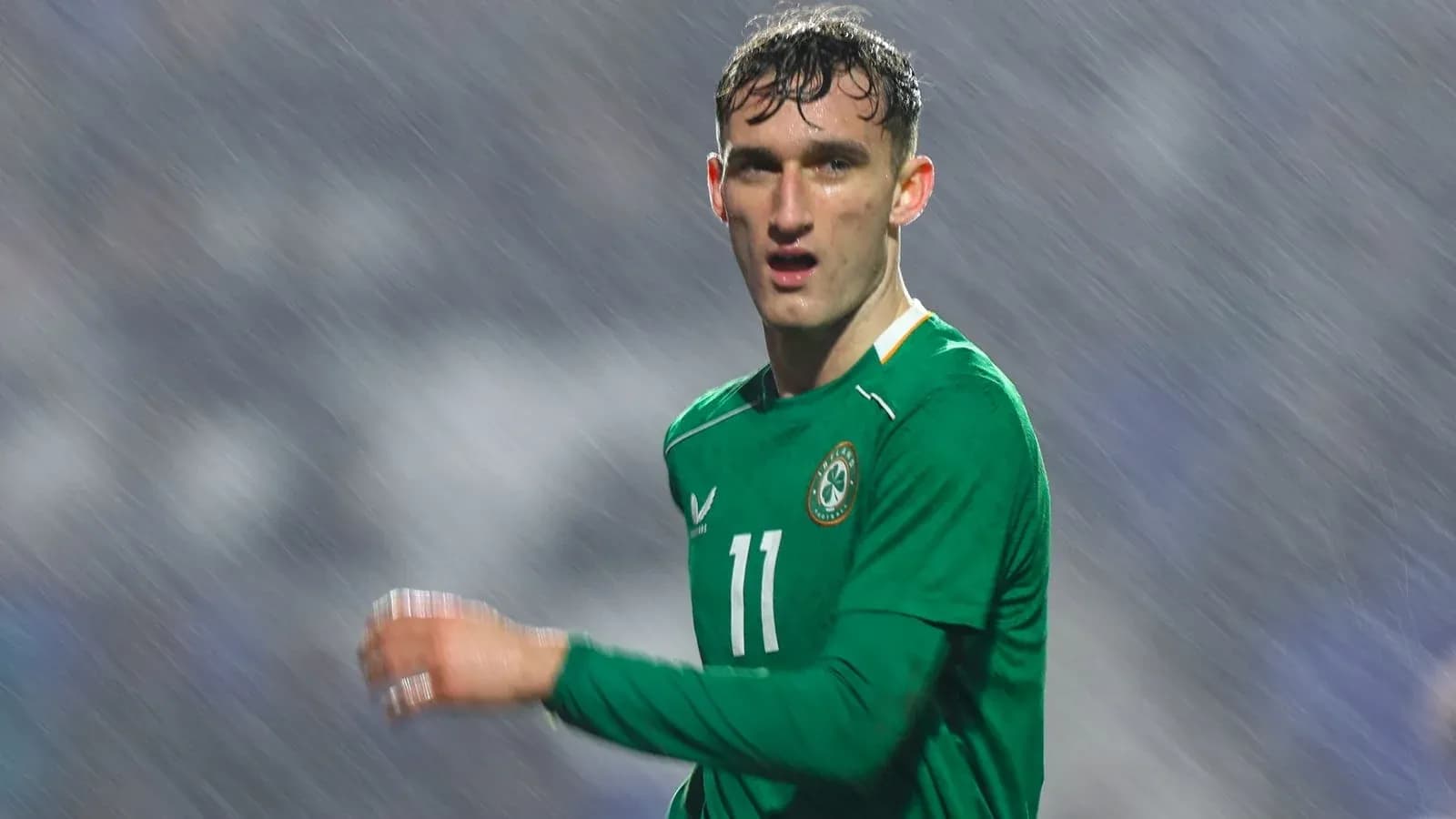 Futbolchi yomg'irda o'yin davomida harakatda Futbolchi yomg'irda o'yin davomida harakatda
