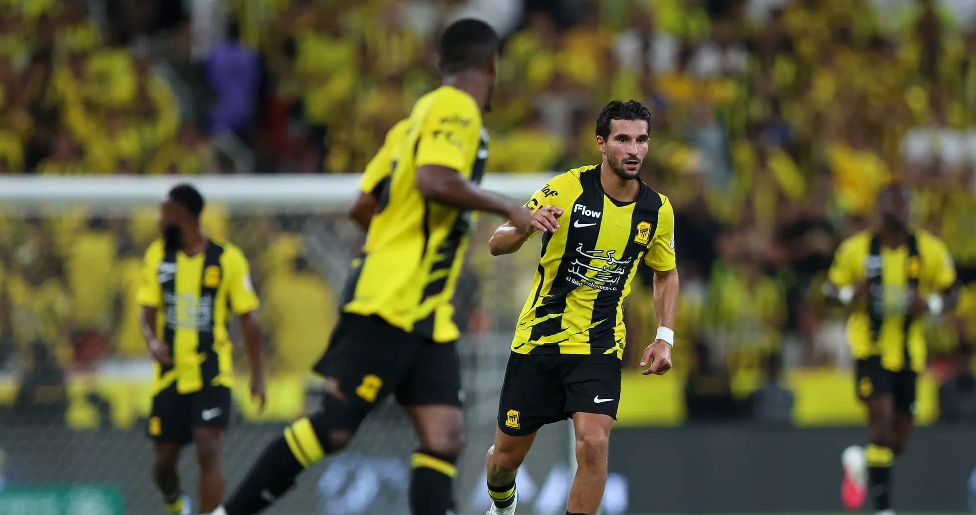 Ittihad players in yellow and black uniforms during match Ittihad players in yellow and black uniforms during match
